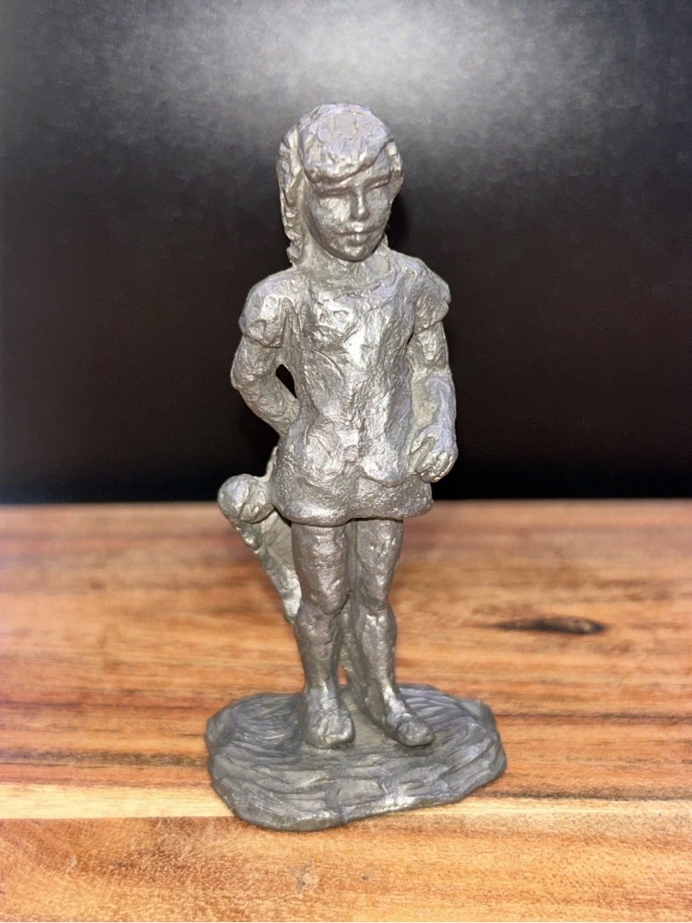 vintage pewter figurine depicting a young girl holding a doll